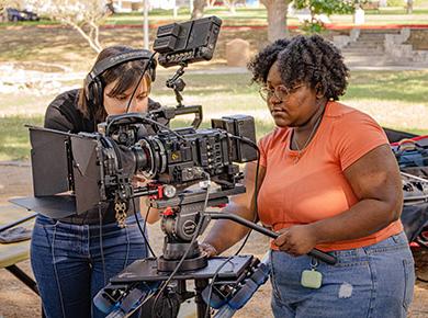 student operating a film camera